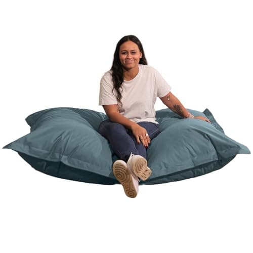 Femme assise sur pouf géant gris foncé extérieur