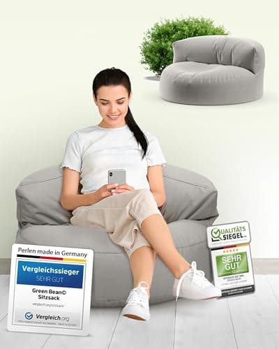 Femme assise sur pouf-canapé gris avec plante décorative